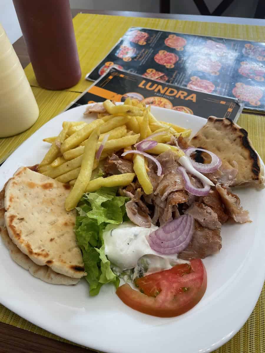 A kebab plate with veal, vegetables, pita, and fries in Albania — cheap local fast food in Europe