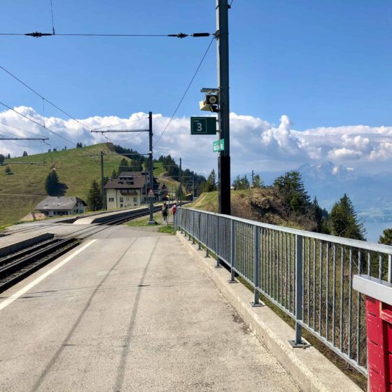 A beautiful backdrop of the Swiss alps towers over Rigi Staffel Train Station on the way up to the summit of Mt Rigi.