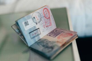 Open passport full of border crossing stamps - a must take for young travellers is a passport