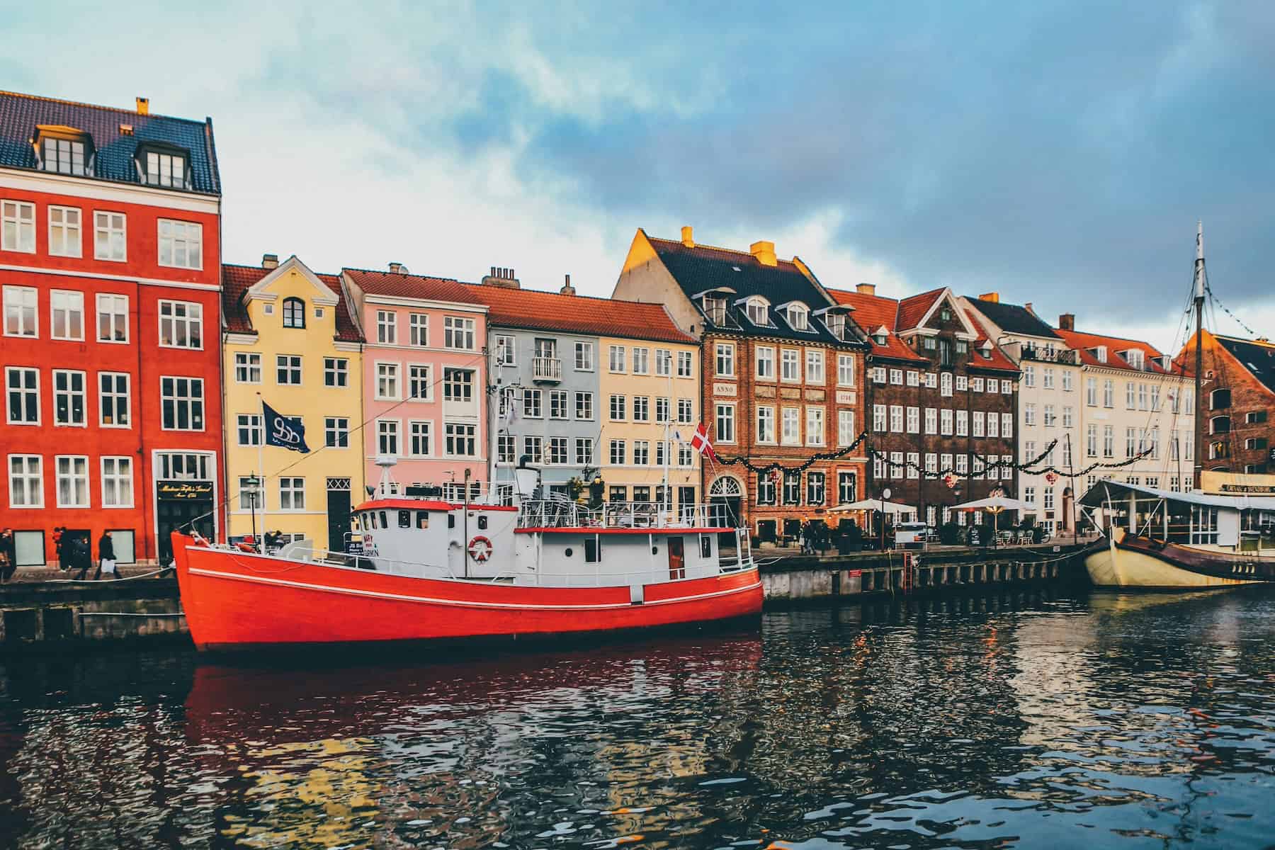 Colourful houses and boats along Nyhavn harbour in Copenhagen, Denmark