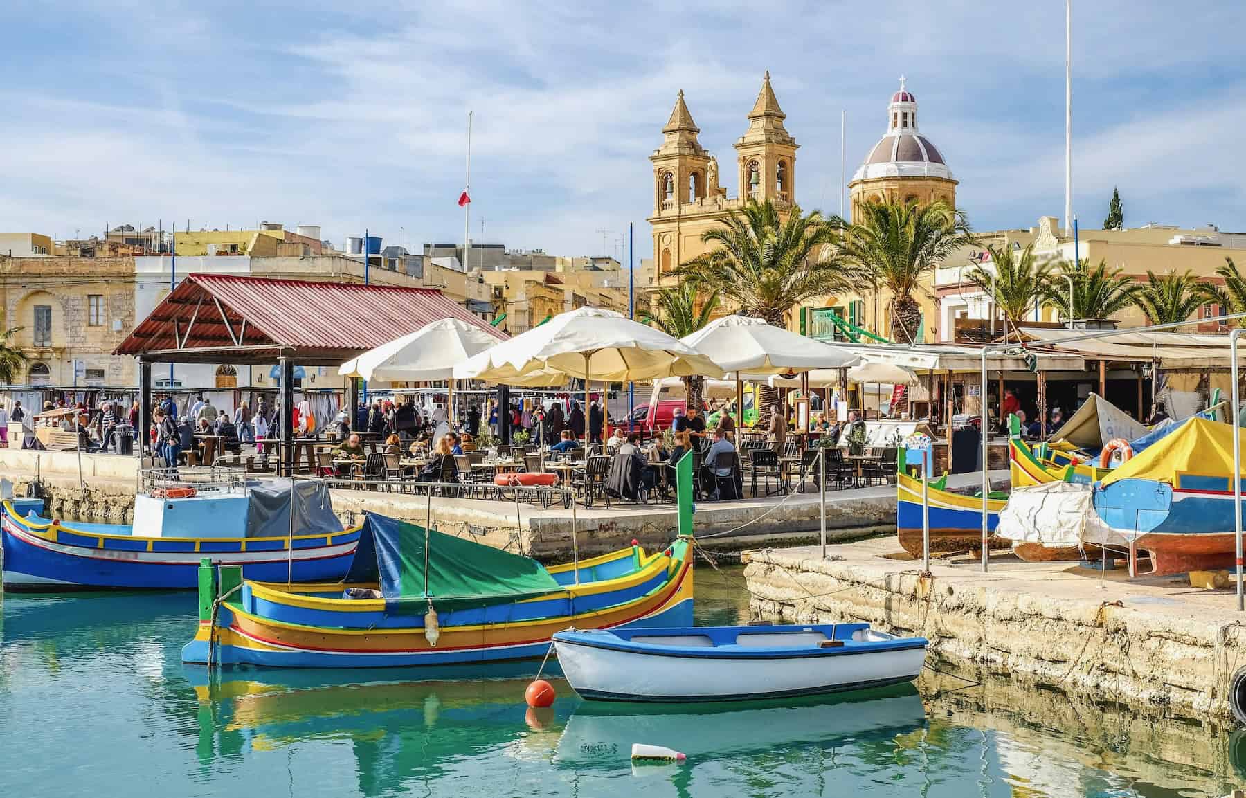 Colourful luzzu fishing boats in Marsaxlokk harbour, Malta